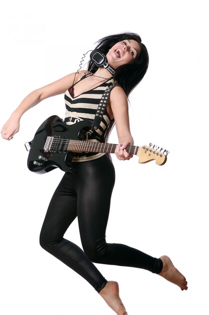 ジャンプしてエレクトリックギターを演奏するロッカー女性