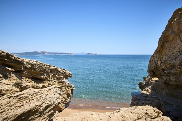 스페인의 Playa Illa Roja 공공 해변에서 바다 해안에있는 바위