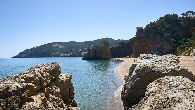 스페인의 Playa Illa Roja 공공 해변에서 바다 해안에있는 바위