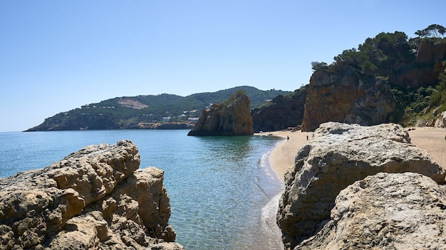 スペインのプラヤイラロハ公共ビーチで海の海岸の岩