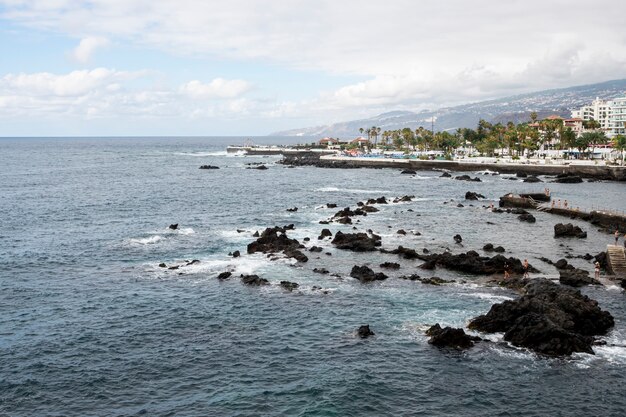 Rocky coastline with city on background