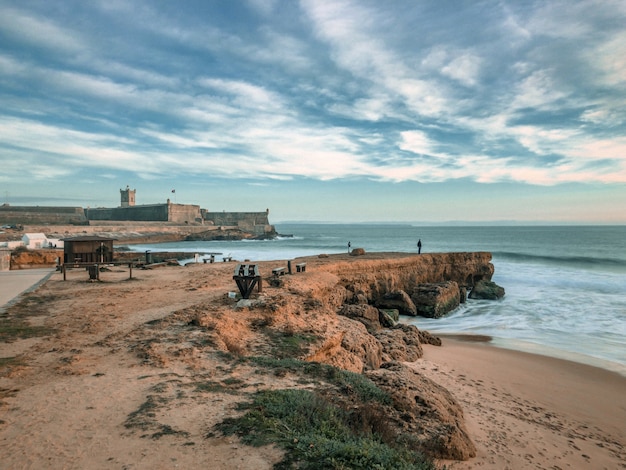 rocky dock near the wavy sea under the cloudy sky