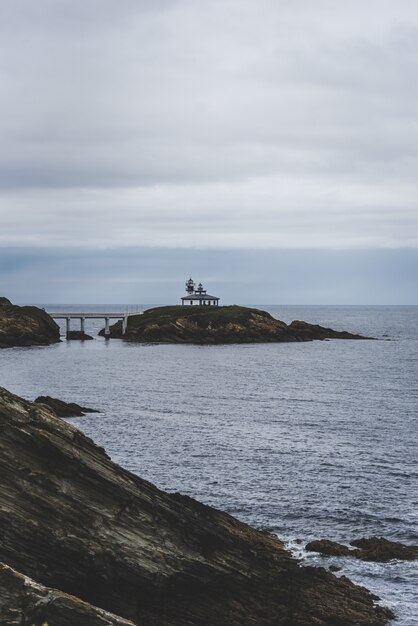 Rocky island surrounded by the sea under a cloudy sky