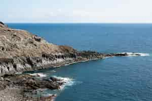 Free photo rocky ocean littoral with clear sky