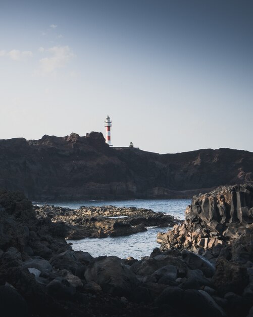 海と灯台の岩の多い海岸