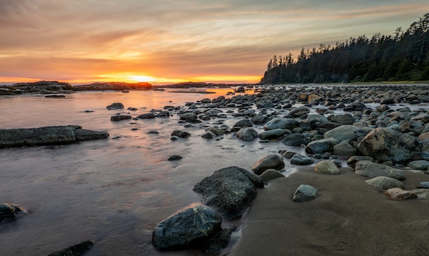 Скалистый берег с камнями на берегу во время заката