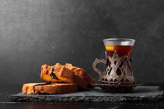 Foto gratuita arrotolare le fette di torta con un bicchiere di tè.