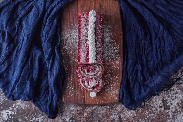 Roll cake with red marmelade on it, top view. 