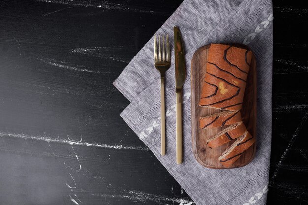 Roll cake on a wooden board, top view.