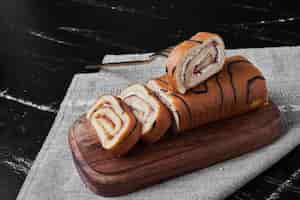 Free photo roll cake on a wooden board.