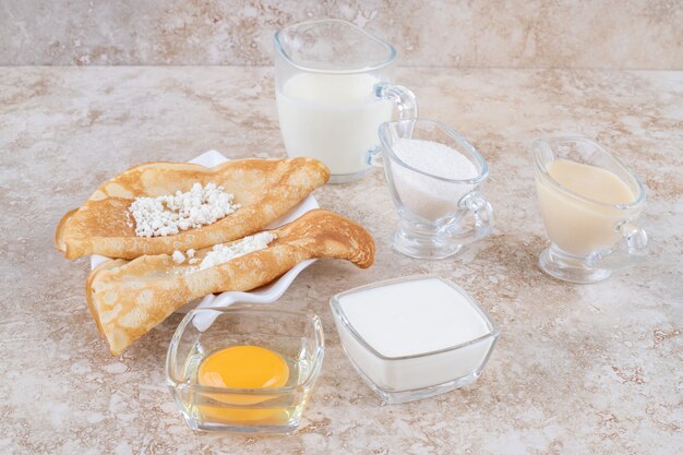 Roll pancakes with cottage cheese and a wooden spoon