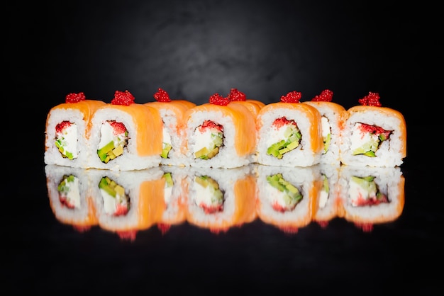 Roll Philadelphia made of salmon, cucumber, nori, pickled rice, cheese, masago caviar