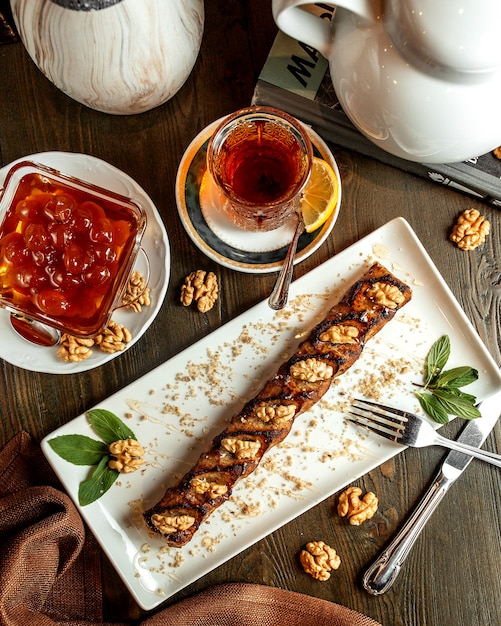 Roll with walnuts served with tea and jam