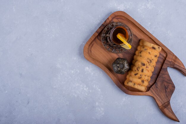 Rollcake served with earl grey tea in a wooden platter