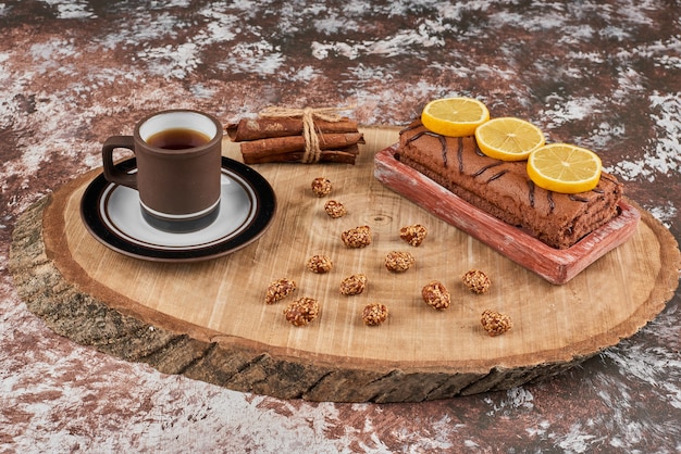 Rollcake and tea on a wooden board.