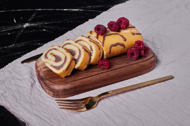 Rollcake with raspberries on a platter