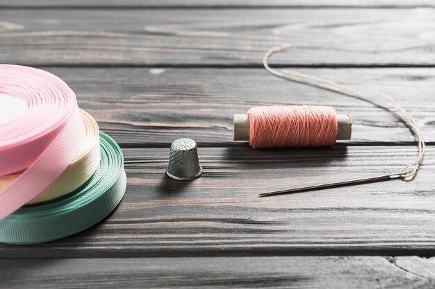 Рулонные цветные ленты и швейные изделия на деревянный стол