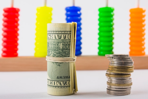 Rolled dollars and coins stack on table