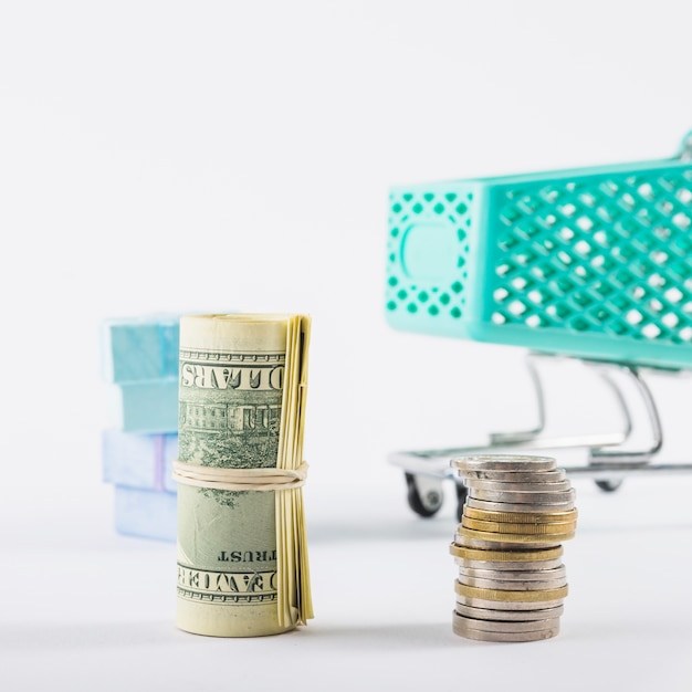 Free photo rolled dollars and coins stack on white table