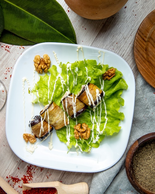  rolled eggplant with  stuffing on ​​a lettuce leaf  with walnuts