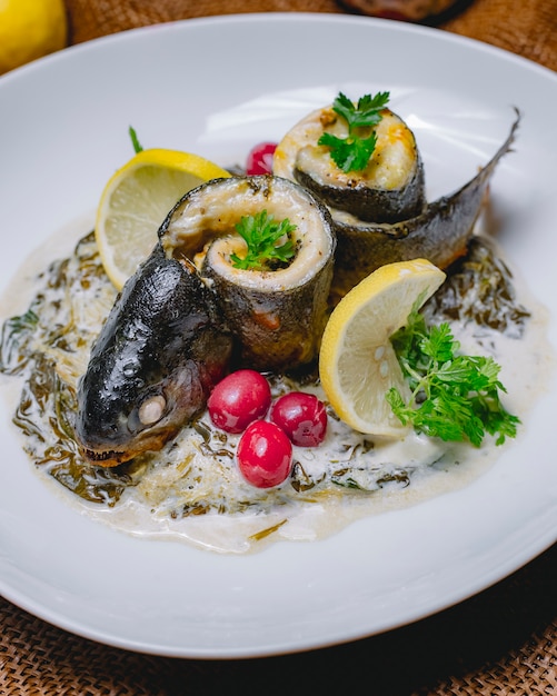 Rolled fish in creamy spinach sauce barberry lemon parsley side view