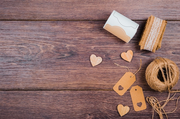 Rolled up lace; wooden heart shape; tags and jute spool on wooden desk