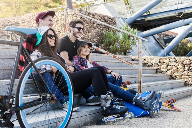 Roller skaters resting near bicycle