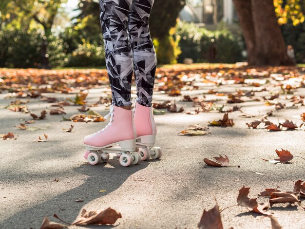 Roller skates on pavement with leaves