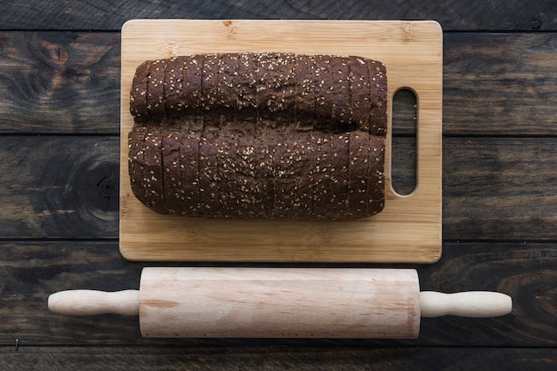 Free photo rolling pin near cut bread