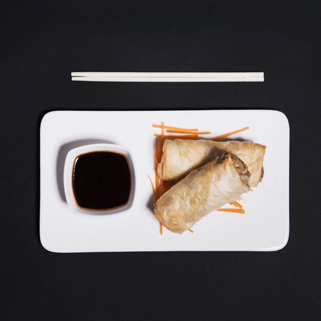 Rolls and soy sauce on black