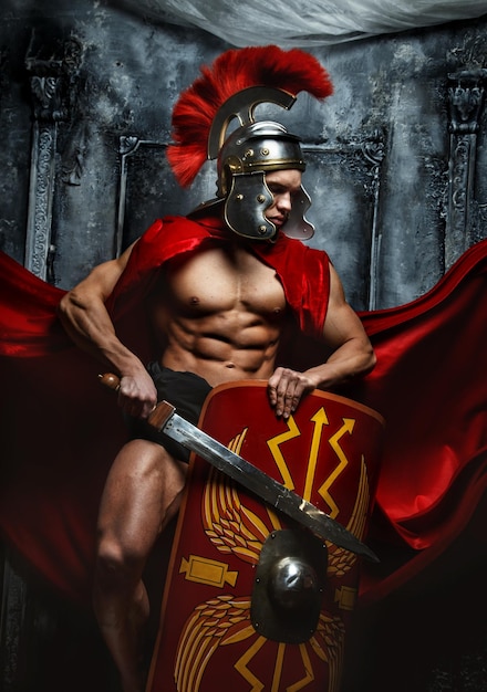 Free photo roman warrior with muscular body holding sword and shield