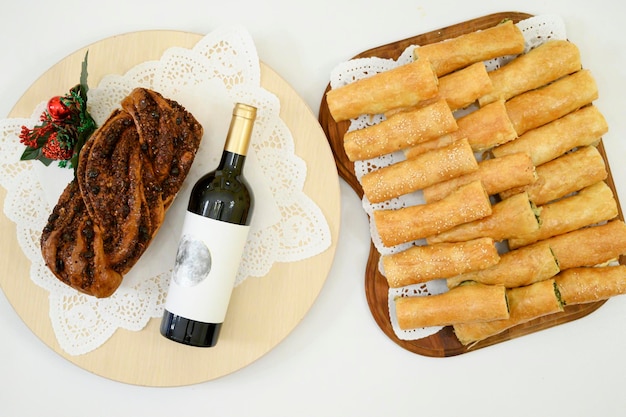 Бесплатное фото Румынский пасхальный хлеб козонак с вином деревянная доска, полная молдавских румынских пирогов