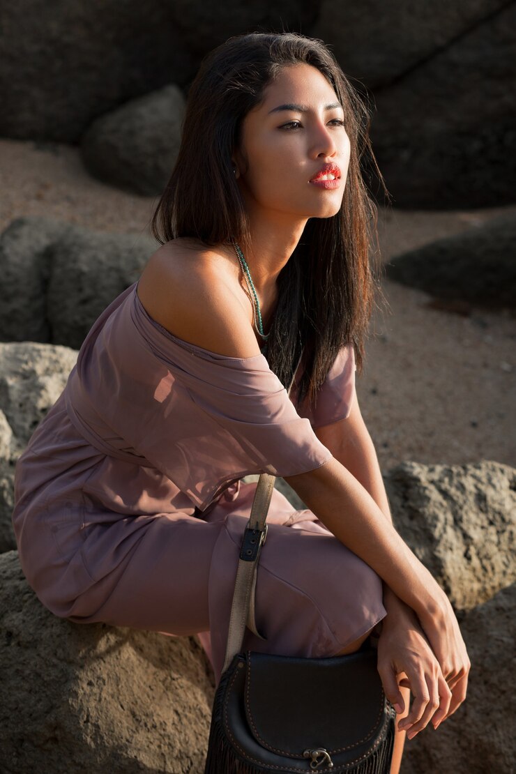 無料Photo rhe岩の上に座って海を見ている夏のドレスのロマンチックなアジアの女性。