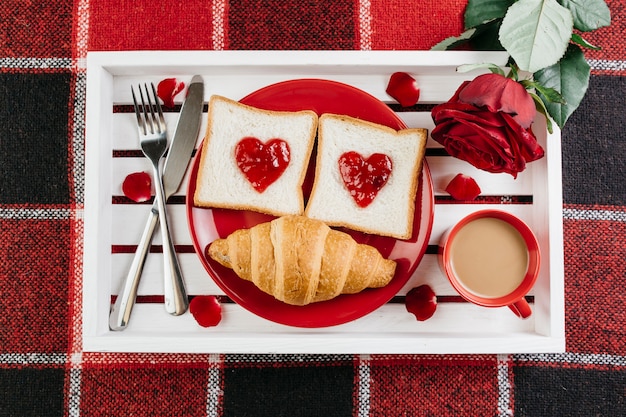 Romantic breakfast on white tray on table 