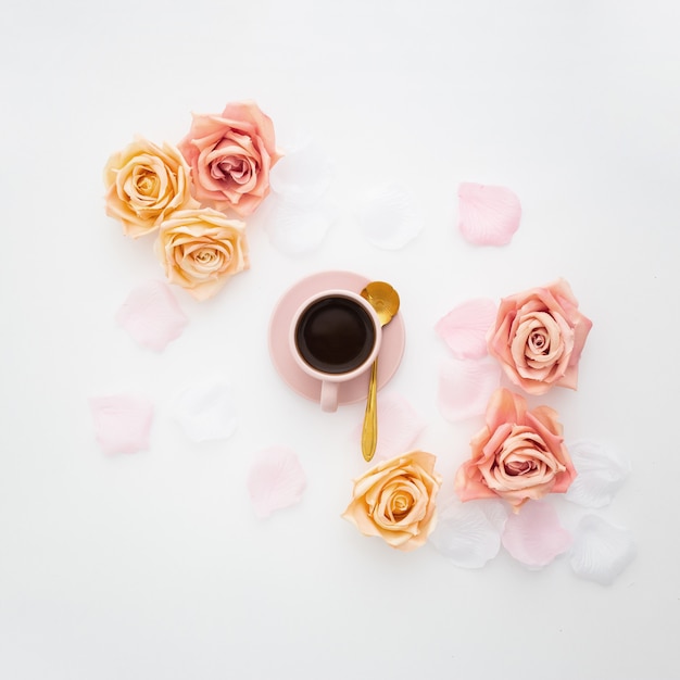 Romantic composition made with a pink cup of coffee and roses