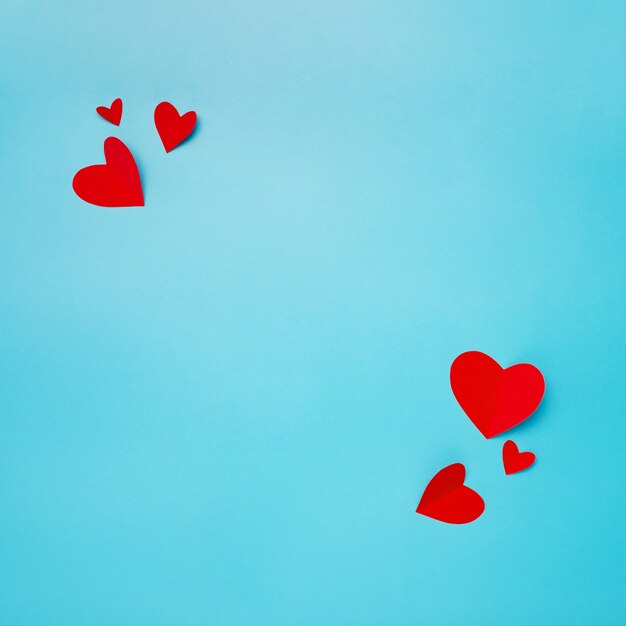 Romantic composition made with red hearts on blue background with copyspace for text