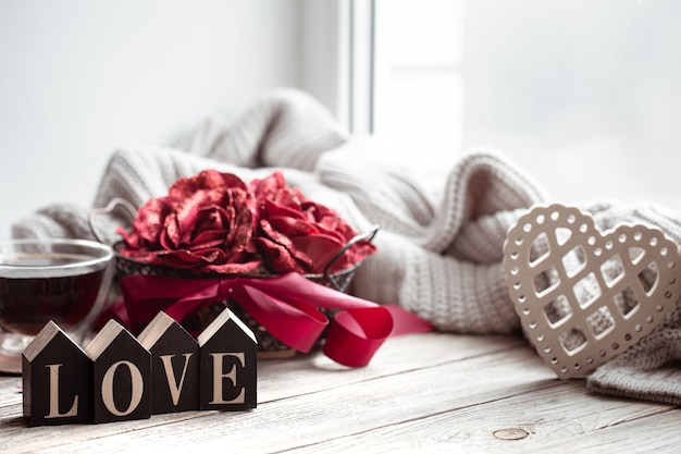 Романтическая композиция на День святого Валентина с декоративным словом love и деталями декора.