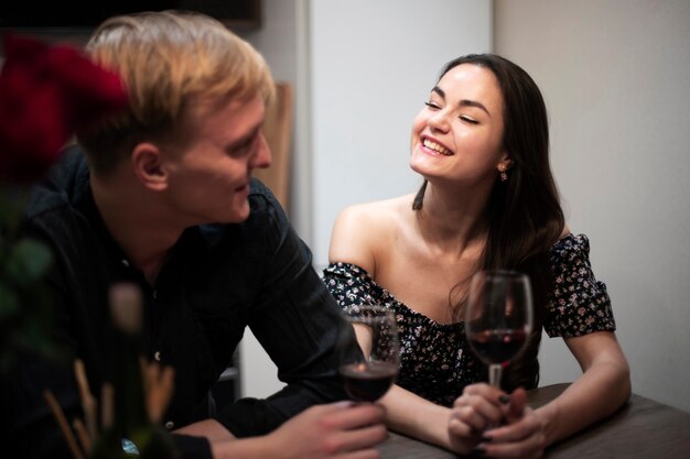 Romantic couple celebrating valentines day at home with wine