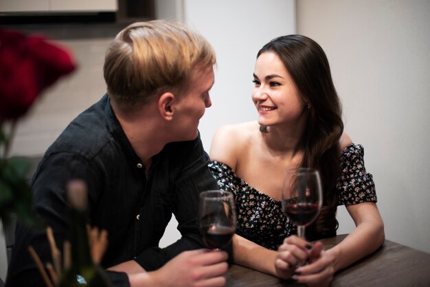 Romantic couple celebrating valentines day at home with wine