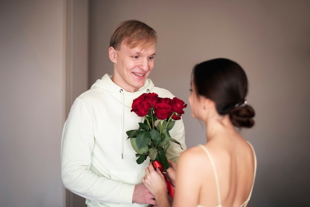 Romantic couple celebrating valentines day with a bouquet of red roses