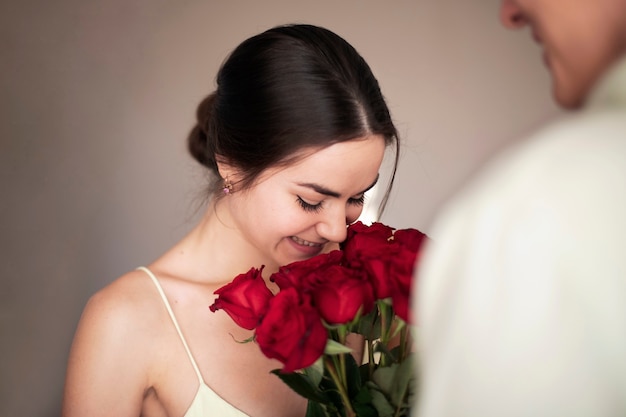 Free photo romantic couple celebrating valentines day with a bouquet of red roses