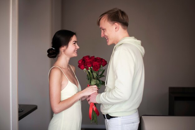 Романтическая пара празднует день святого валентина с букетом красных роз