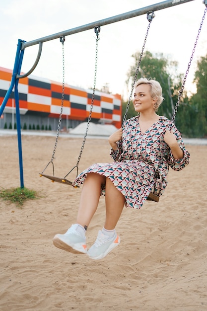 Foto gratuita la coppia romantica si diverte fuori. godersi il tempo insieme su un'altalena.