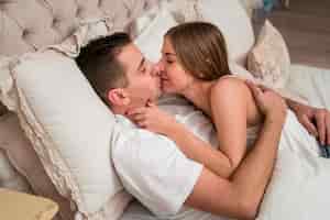 Free photo romantic couple kissing in bed