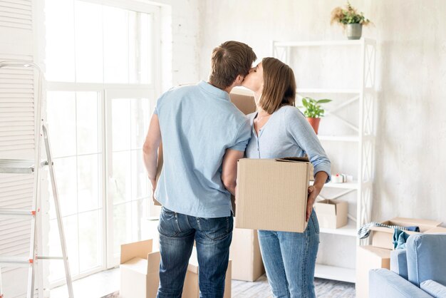 Romantic couple kissing each other while packing to move out