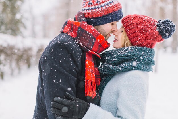 Romantic couple kissing in snowflakes