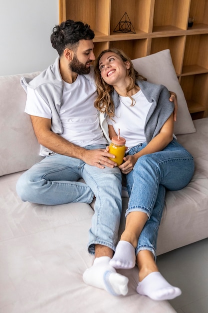 Бесплатное фото Романтическая пара на диване у себя дома с соком