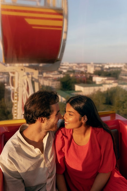 Free photo romantic couple out together at the ferris wheel in the park