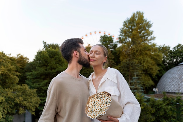 Free photo romantic couple out together at the ferris wheel in the park