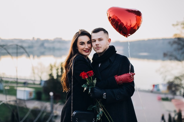 Foto gratuita coppie romantiche che posano alla macchina fotografica con il pallone